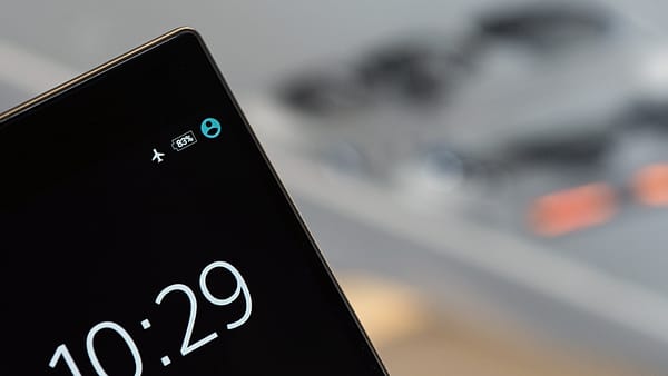 A smartphone held in one hand with its display lit against a dark background
