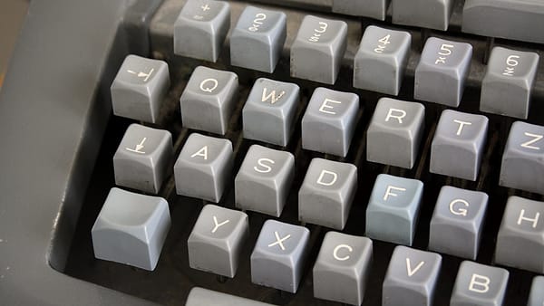 The keys of a manual typewriter photographed close up, the letters worn with use