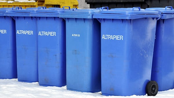 Waste paper bins standing side by side in an office corridor