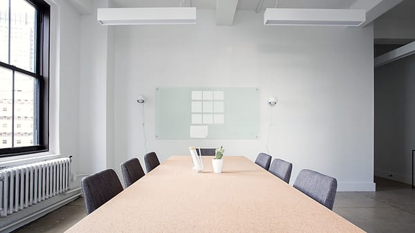 A conference room with a long table and chairs arranged around it