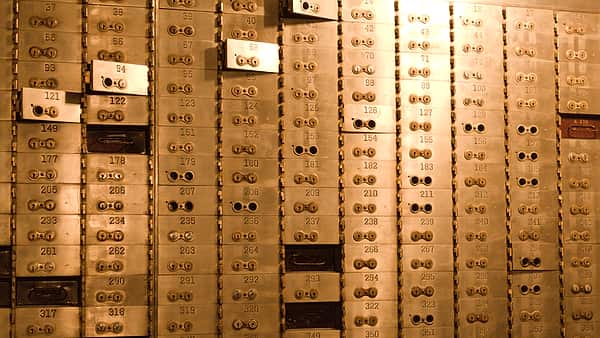 A wall of numbered safe deposit boxes with their small doors closed