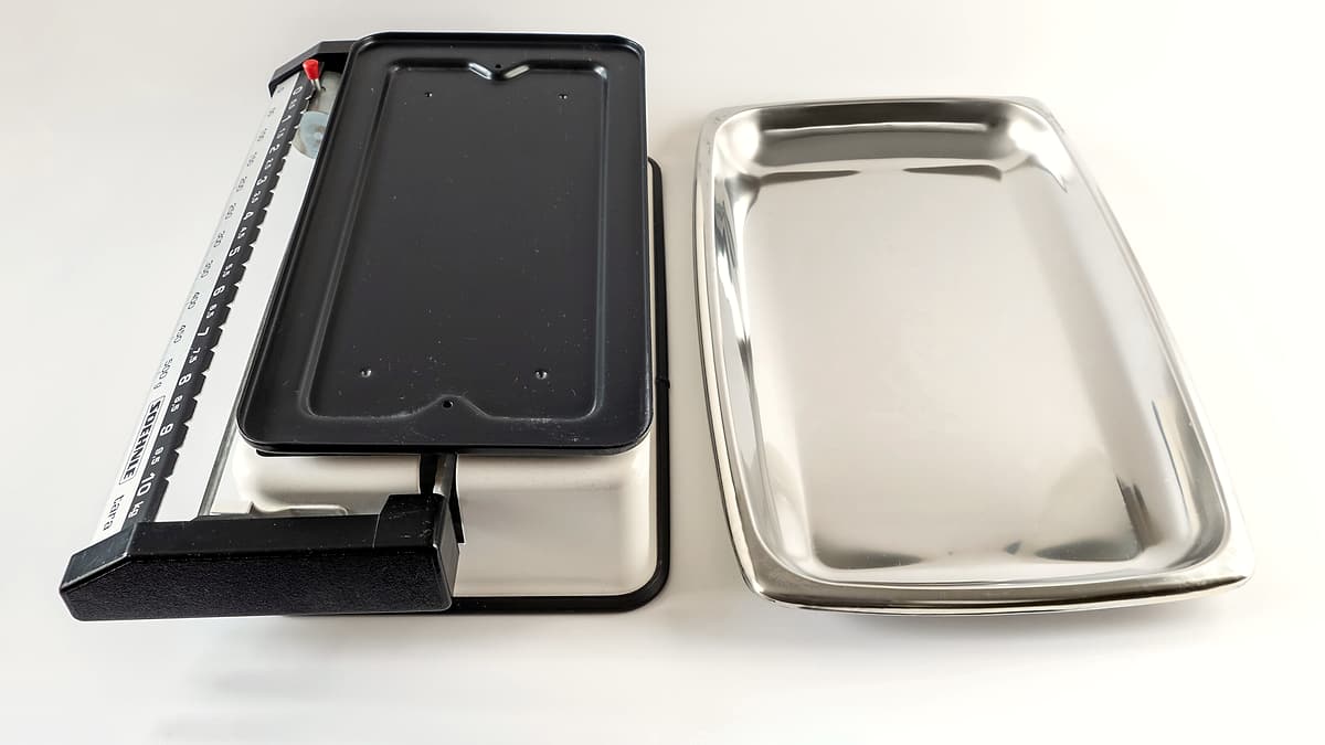 A kitchen weighing scale with a detachable tray, photographed on a work surface